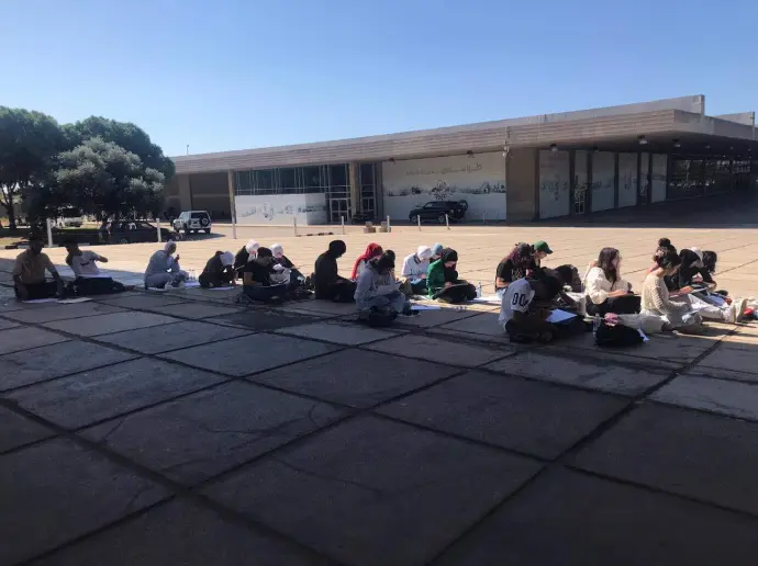 	“Outdoor learning session at Rachid Karami International Fair plaza under clear sky”